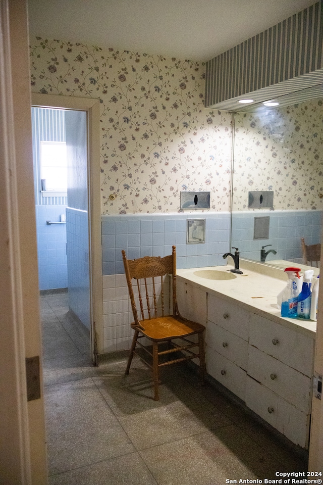 bathroom featuring tile walls and sink