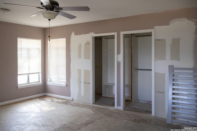 unfurnished bedroom featuring two closets and ceiling fan