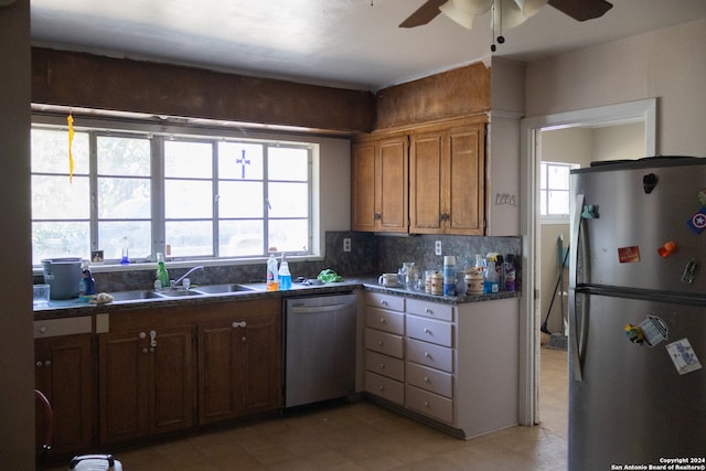 kitchen featuring ceiling fan, stainless steel appliances, backsplash, and sink