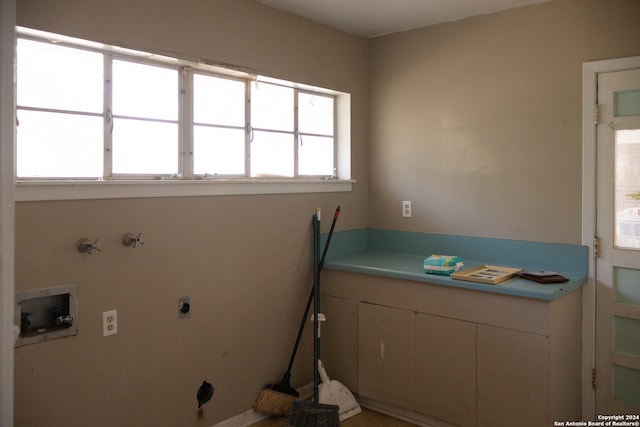 clothes washing area featuring hookup for a washing machine, hookup for a gas dryer, hookup for an electric dryer, and cabinets