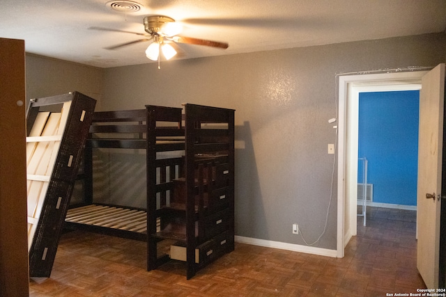 bedroom with ceiling fan and dark parquet flooring