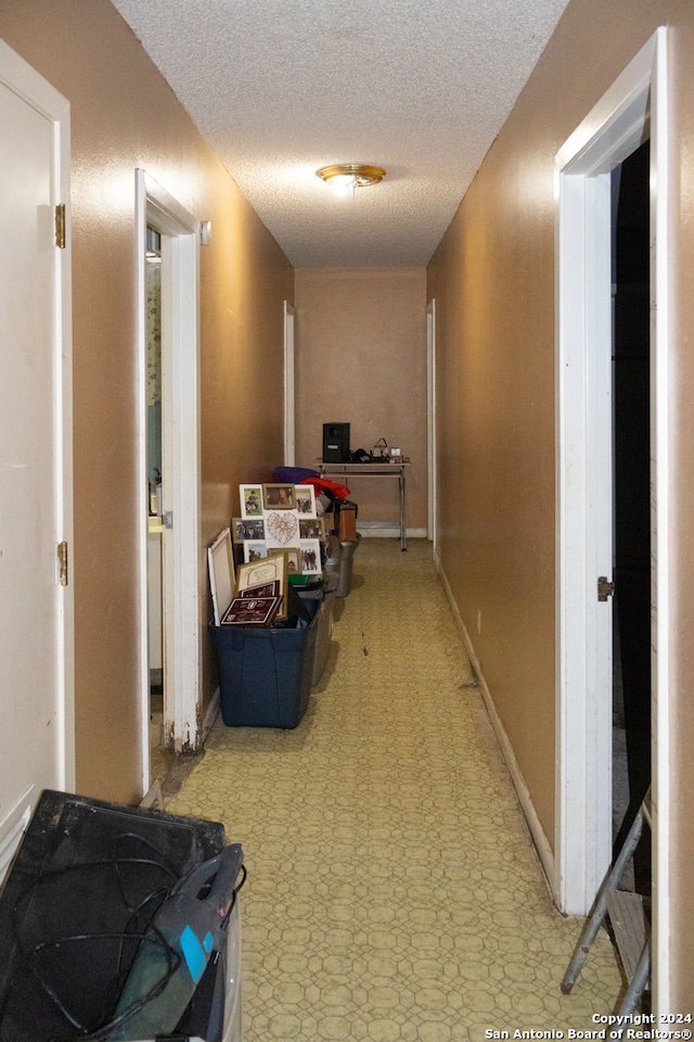 hall featuring a textured ceiling