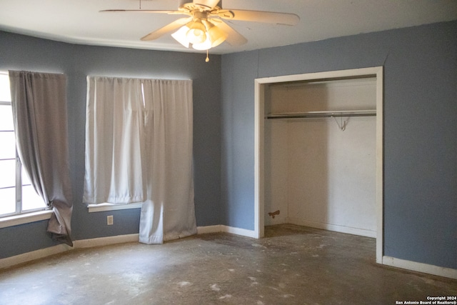 unfurnished bedroom featuring concrete flooring, a closet, and ceiling fan