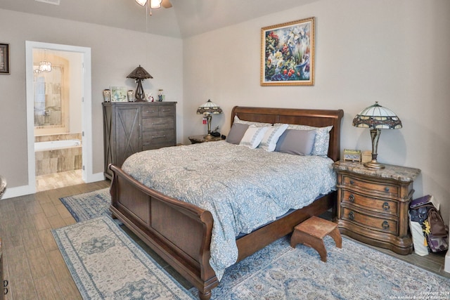 bedroom featuring hardwood / wood-style floors, ceiling fan, and ensuite bath