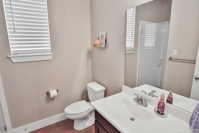 bathroom featuring hardwood / wood-style flooring, vanity, toilet, and walk in shower