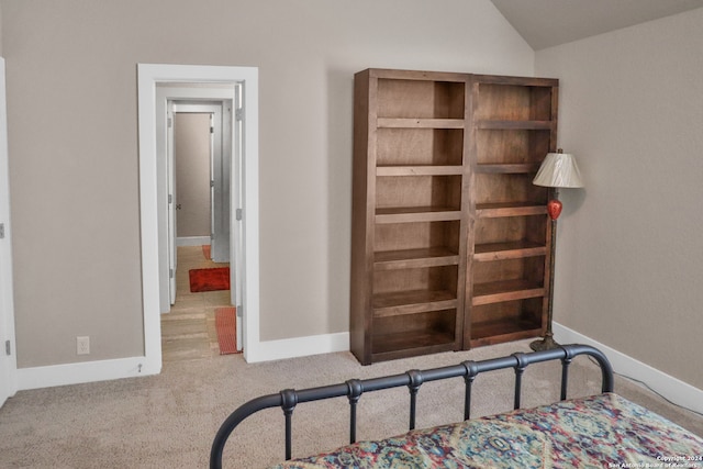 bedroom featuring lofted ceiling and light carpet