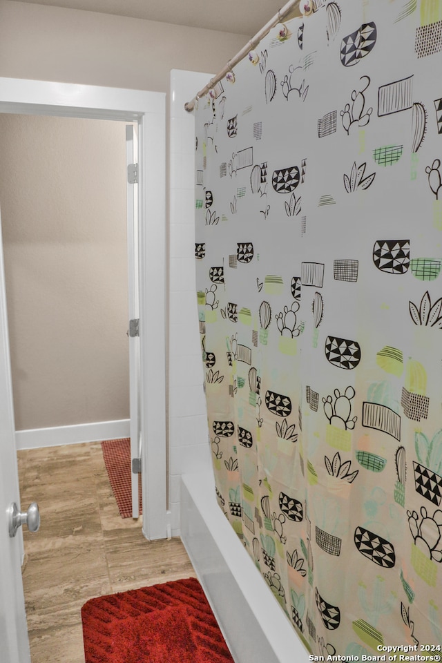 bathroom featuring hardwood / wood-style floors and shower / bath combo