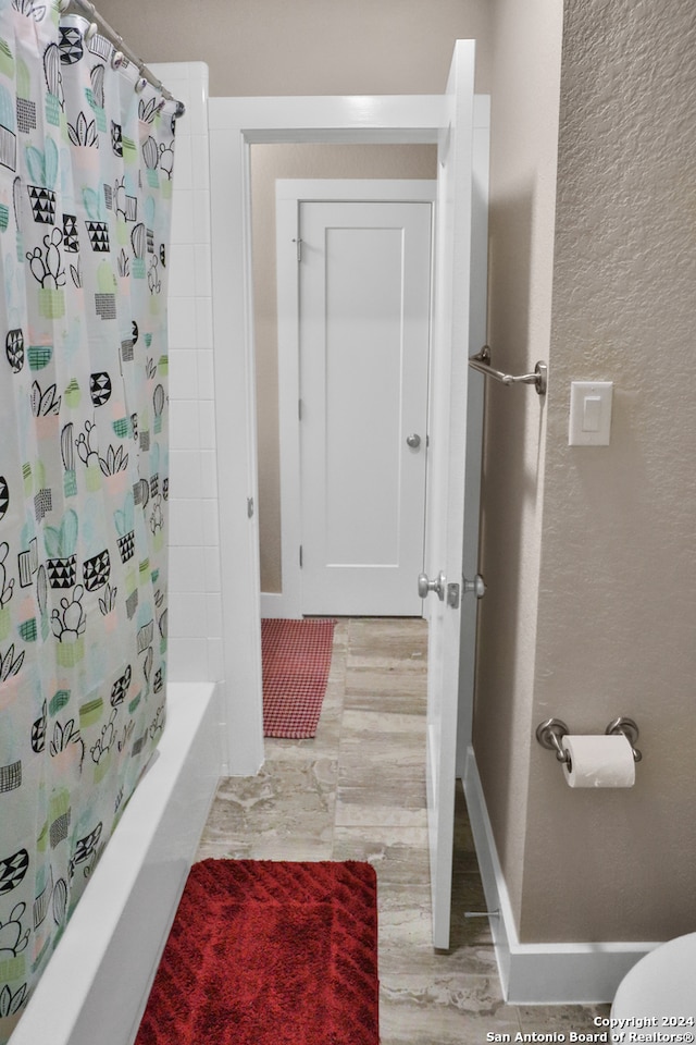 bathroom with shower / bath combo with shower curtain