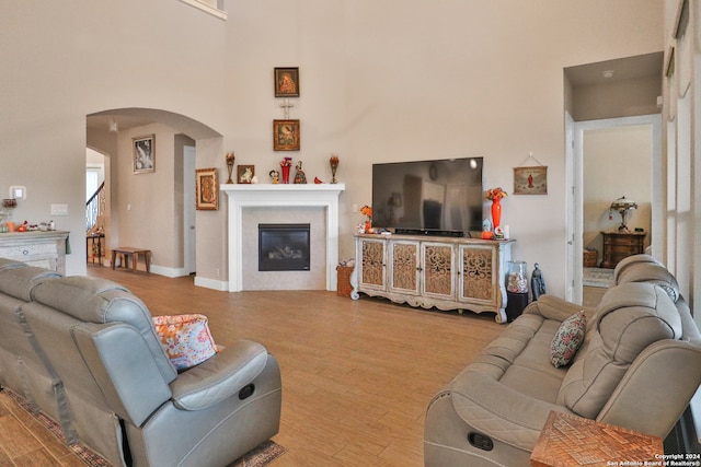 living room featuring light wood-type flooring and a high ceiling