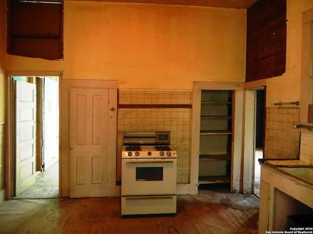 kitchen featuring dark carpet and white gas range oven