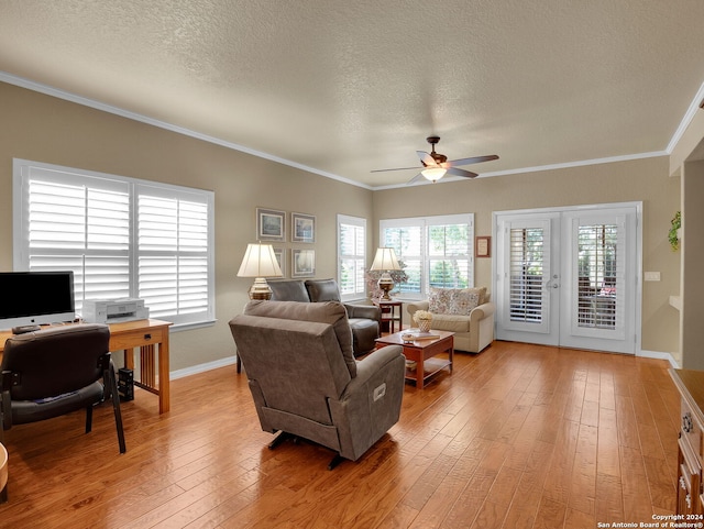 living room with a textured ceiling, crown molding, ceiling fan, and light hardwood / wood-style flooring