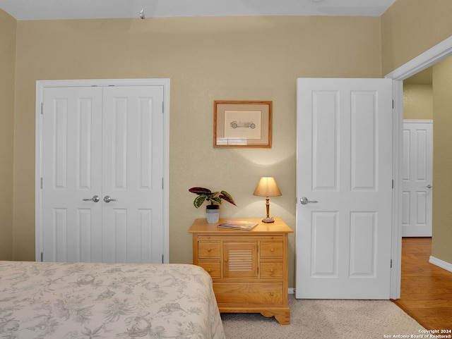 bedroom with light hardwood / wood-style floors and a closet