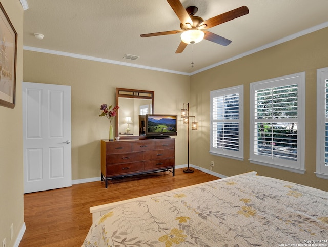 bedroom featuring wood-type flooring, crown molding, and ceiling fan