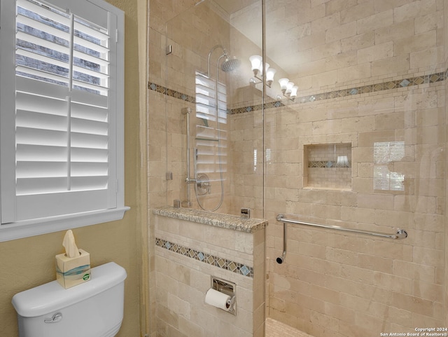 bathroom with toilet, a healthy amount of sunlight, and tiled shower