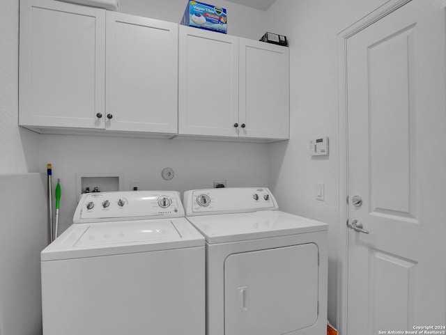 washroom with washing machine and clothes dryer and cabinets