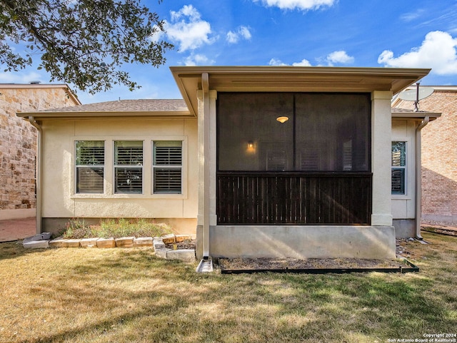 exterior space featuring a sunroom and a yard