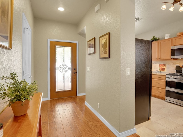 foyer entrance featuring a textured ceiling and light hardwood / wood-style flooring