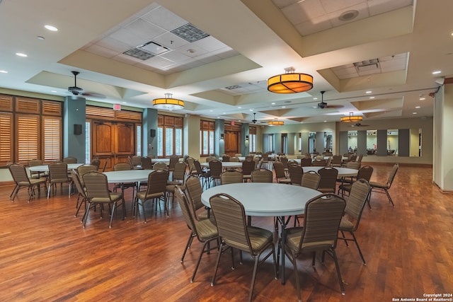 dining room with a raised ceiling, wood-type flooring, ceiling fan, and coffered ceiling