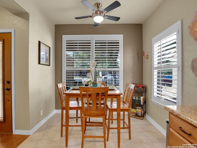 tiled dining space featuring ceiling fan