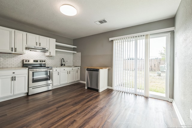 kitchen with white cabinets, stainless steel appliances, dark hardwood / wood-style floors, and a wealth of natural light