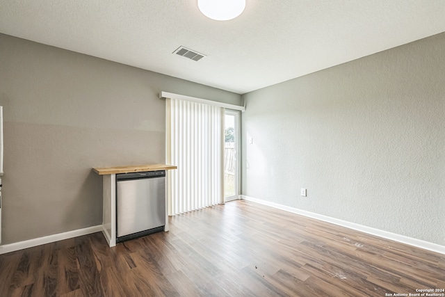 empty room with a textured ceiling and dark wood-type flooring