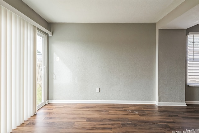 unfurnished room featuring dark hardwood / wood-style flooring and a wealth of natural light