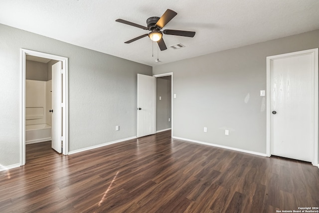 unfurnished bedroom with connected bathroom, ceiling fan, dark hardwood / wood-style floors, and a textured ceiling