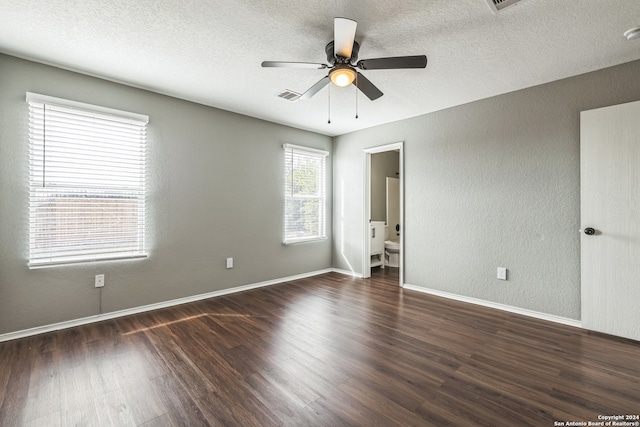 unfurnished bedroom with connected bathroom, ceiling fan, dark hardwood / wood-style floors, and a textured ceiling