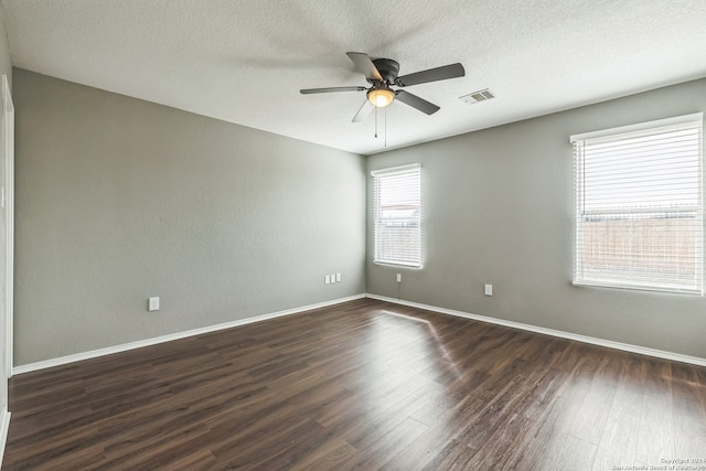 unfurnished room with ceiling fan, dark wood-type flooring, and a textured ceiling