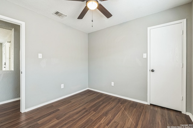 spare room with a textured ceiling, dark hardwood / wood-style floors, and ceiling fan