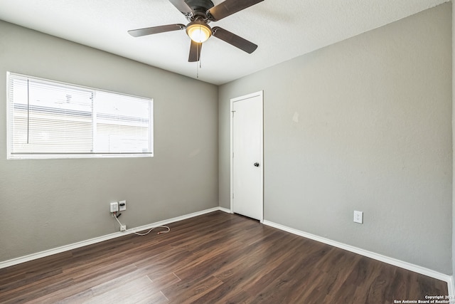 spare room featuring ceiling fan and dark wood-type flooring