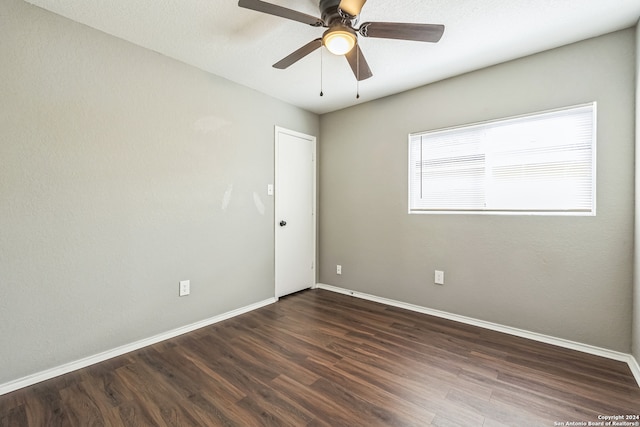 spare room featuring ceiling fan and dark wood-type flooring