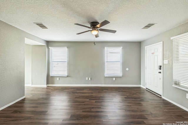 empty room featuring a textured ceiling, dark hardwood / wood-style flooring, and ceiling fan