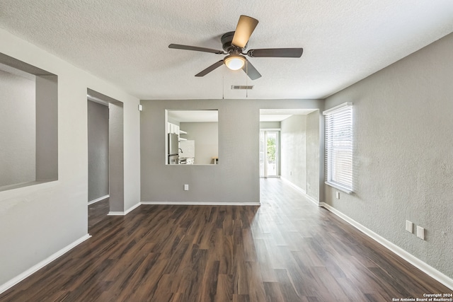 unfurnished room with a textured ceiling, ceiling fan, and dark wood-type flooring