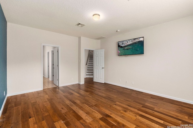 unfurnished room featuring hardwood / wood-style flooring and a textured ceiling