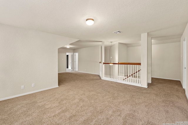 spare room featuring carpet flooring and a textured ceiling