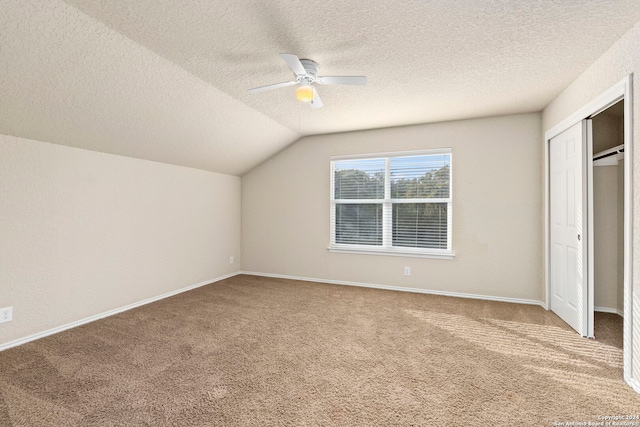 bonus room with ceiling fan, carpet floors, vaulted ceiling, and a textured ceiling