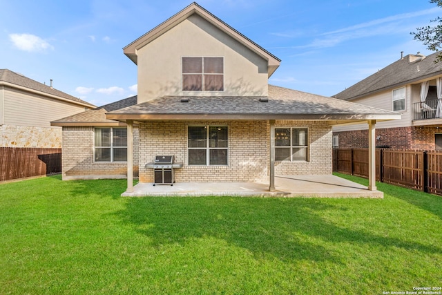 rear view of property with a lawn and a patio area