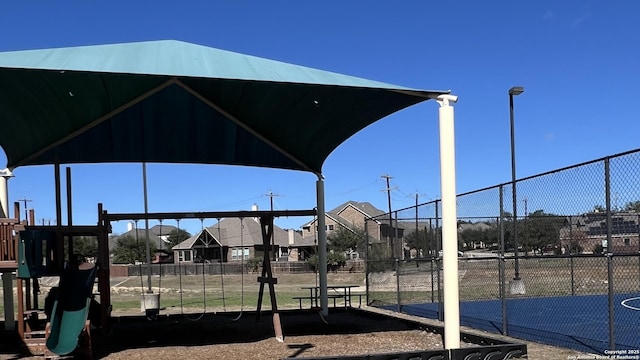 community jungle gym with a residential view and fence