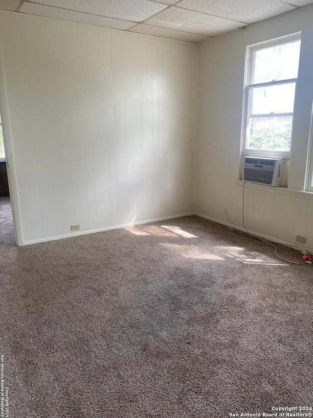 spare room with carpet, a drop ceiling, and cooling unit