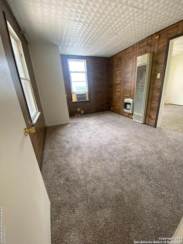 2019 Martin Luther King Dr, San Antonio, TX 78203 - spare room with cooling unit, carpet floors, wooden walls, and heating unit