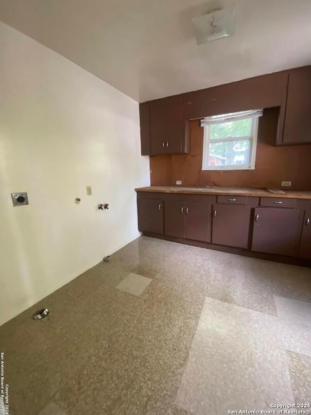 2019 Martin Luther King Dr, San Antonio, TX 78203 - kitchen featuring backsplash and dark brown cabinets
