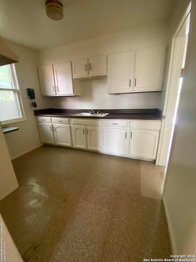 2019 Martin Luther King Dr, San Antonio, TX 78203 - kitchen with a sink, white cabinets, and dark countertops