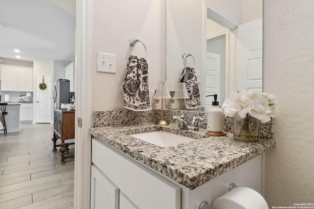 3443 Iron Cyn, Bulverde, TX 78163 - bathroom featuring a textured wall, wood finished floors, vanity, and recessed lighting