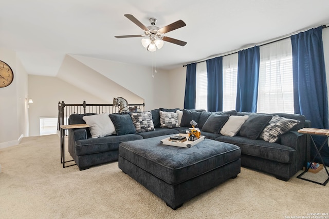 carpeted living room with ceiling fan and vaulted ceiling