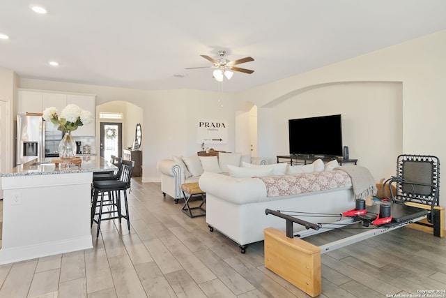 living room featuring light hardwood / wood-style flooring and ceiling fan