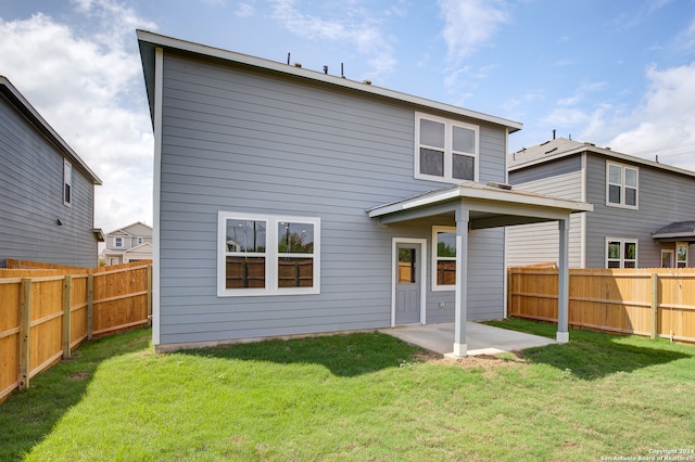 rear view of house featuring a lawn and a patio area