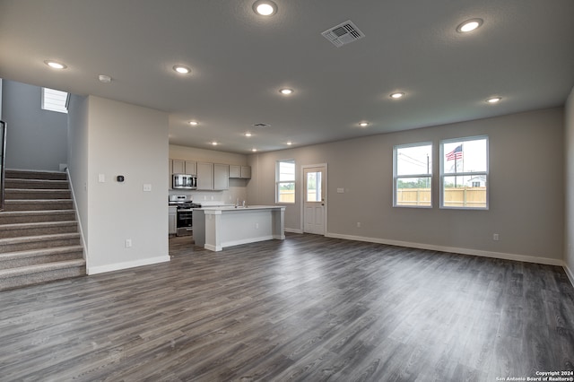 unfurnished living room with sink and dark wood-type flooring