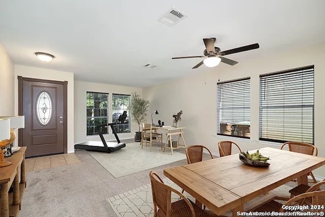 carpeted dining room with ceiling fan