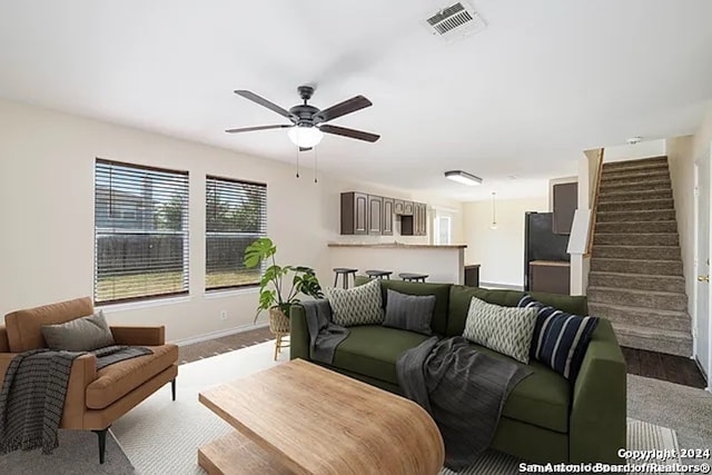 living room featuring ceiling fan and light colored carpet